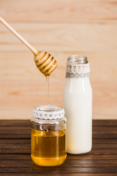botella de vidrio de leche con miel en frasco
 - Foto, imagen