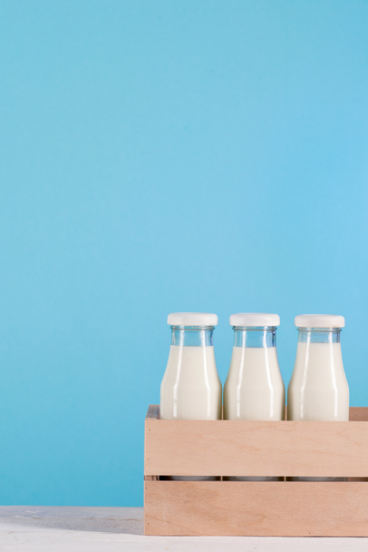 üveg palackok tej fadobozban - Fotó, kép