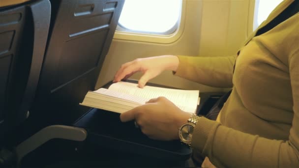 Film kobieta z książką w samolocie w 4k - Materiał filmowy, wideo
