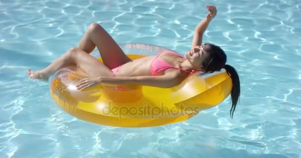 Расслабленная молодая женщина загорает в бассейне
 - Кадры, видео