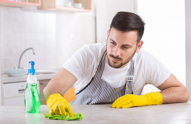 Homem limpando mesa de cozinha
 - Foto, Imagem