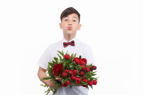 boy holding bunch of flowers - Фото, зображення