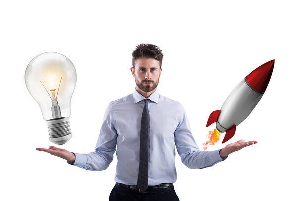 Un homme d'affaires compare une ampoule à une fusée
 - Photo, image