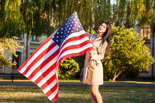 Belle femme heureuse avec drapeau américain célébrant le jour de l'indépendance
.  - Photo, image