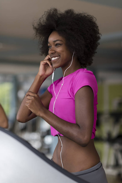 afro american woman running on a treadmill - 写真・画像