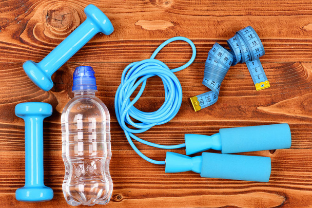 sport objects concept, bottle, skipping rope, measuring tape and dumbbells - 写真・画像