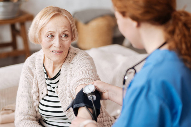 Calma signora anziana avere la sua pressione sanguigna controllata
 - Foto, immagini