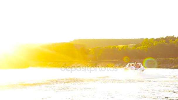 μηχανοκίνητο σκάφος επιπλέει στον ποταμό στην όμορφη ακτίνες του ήλιου, σιλουέτες των δυο ερωτευμένοι πλέει σε ένα μηχανοκίνητο σκάφος - Πλάνα, βίντεο