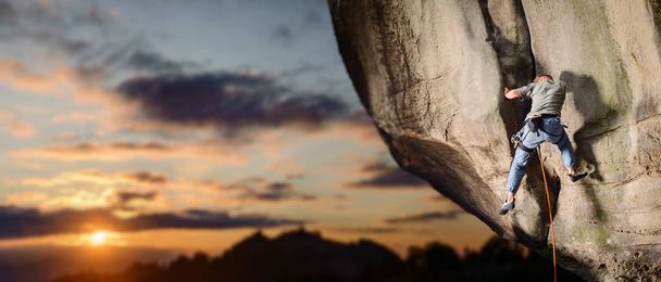 Homme grimpeur escalade gros rocher dans la nature avec corde
 - Photo, image