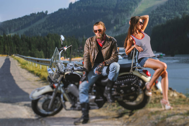 Pari seisoo moottoripyörän vieressä
 - Valokuva, kuva