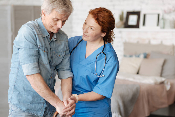 Friendly focused nurse encouraging her elderly patient - Valokuva, kuva