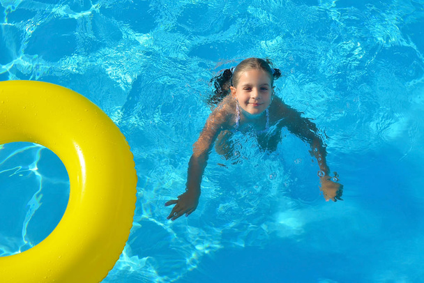 Очаровательный ребенок расслабляется в бассейне
 - Фото, изображение