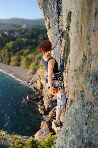 Női mászó hegymászó kötél, sziklás falon - Fotó, kép