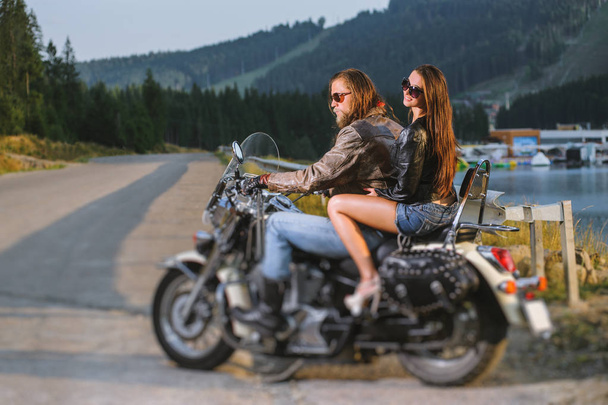 Pareja jinetes sentados juntos en brillante motocicleta cruiser a medida
 - Foto, imagen