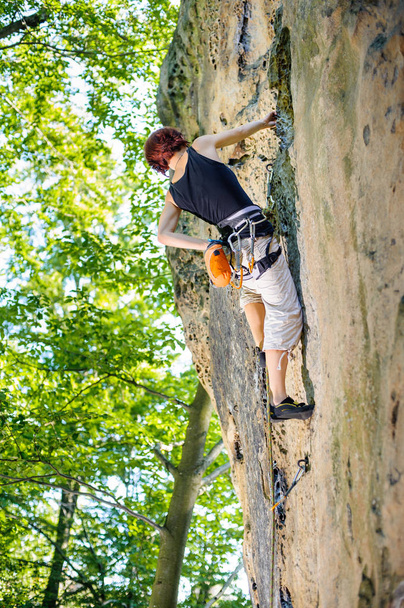 Escaladora trepadora con cuerda en una pared rocosa
 - Foto, Imagen