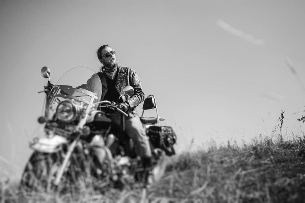 Brutal biker sitting on his motorcycle on a sunny day - Valokuva, kuva