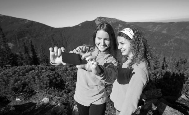 Dos mujeres excursionistas felices sonriendo y tomando foto selfie
 - Foto, Imagen
