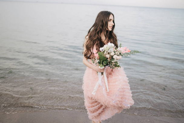 girl with bouquet, alfresco on beach - Фото, зображення