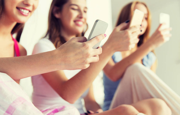 friends or teen girls with smartphones at home - Foto, imagen