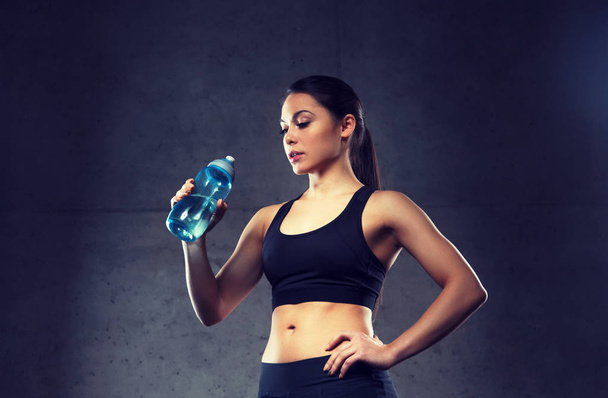 woman drinking water from bottle in gym - Foto, Imagem