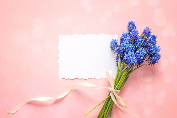 Empty paper card with bouquet of blue muscari flowers on pink ba - Foto, Imagen