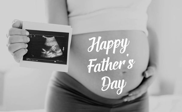 Pregnant woman holding ultrasound photo. Fathers day. - Photo, image