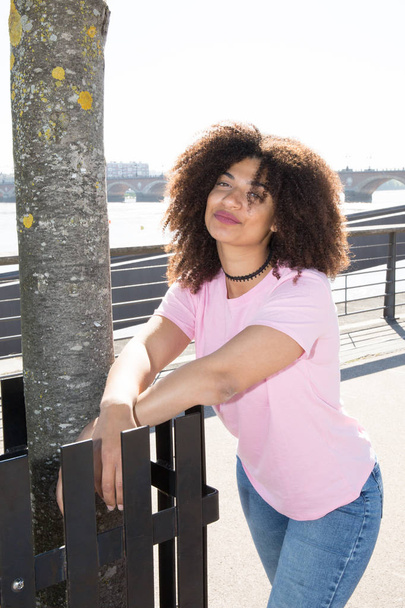 pretty young woman in pink t-shirt with curly hair - Zdjęcie, obraz