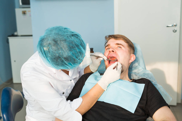 Dentista che effettua un trattamento dentale su un paziente - Foto, immagini