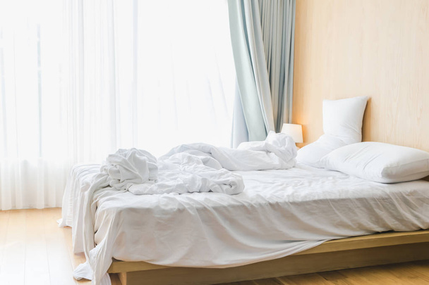 Bed sheets and pillows messed up after nights sleep ,comfort and bedding in a hotel room, concept travel and vacation - Valokuva, kuva