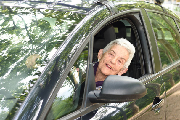 senior woman driving a car - Foto, afbeelding