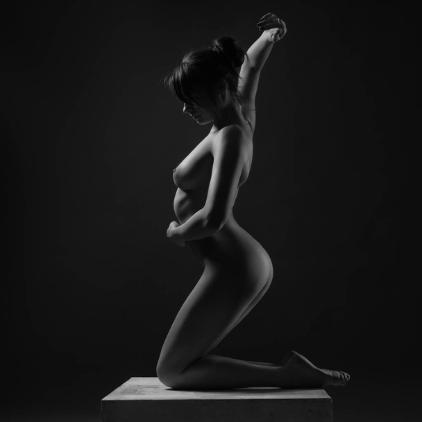 Beautiful body of young woman over dark background - Photo, image