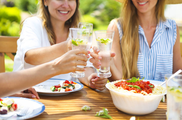 Onnellisia naispuolisia ystäviä lasit limonadia ruokapöydässä
 - Valokuva, kuva