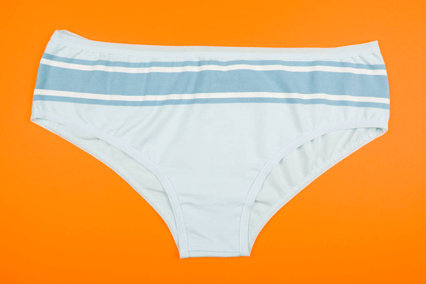 Women's cotton panties flowered isolated on orange background. - Photo, Image