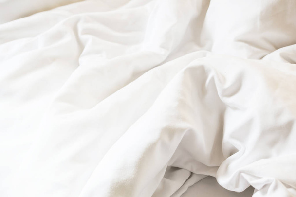 white pillow on bed and with wrinkle messy blanket in bedroom - Fotó, kép