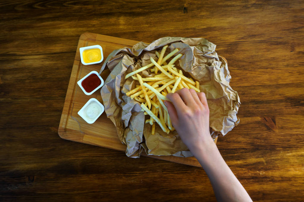 Woman eating fries with sauce in cafe, top view photo - Fotografie, Obrázek