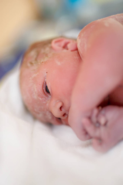 Bambino appena nato secondi e minuti dopo la nascita sdraiato su un asciugamano
 - Foto, immagini