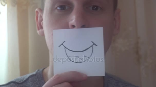 mladý muž ukazuje své emoce s kouskem papíru - Záběry, video