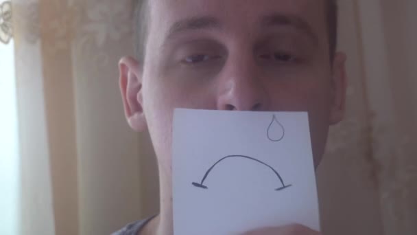 młody człowiek pokazuje swoje emocje z kawałkiem papieru - Materiał filmowy, wideo