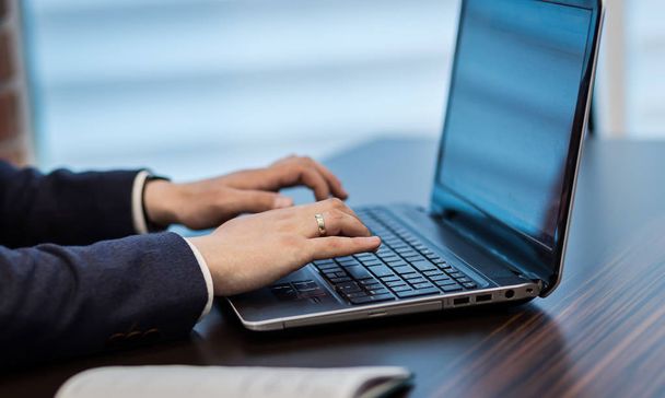 homem de negócios sentado atrás de um laptop, homem de negócios sério sentado atrás de uma mesa em seu laptop, empresário trabalhando Laptop Conectando Networking Concept
 - Foto, Imagem