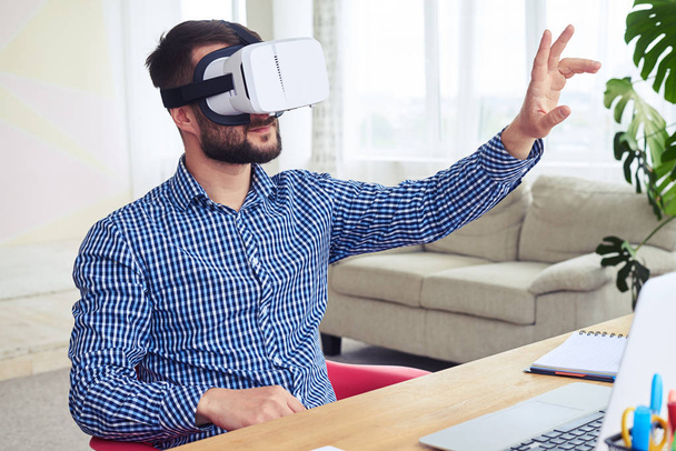 attraente maschio in VR occhiali orientarsi nello spazio seduto a tavola
 - Foto, immagini