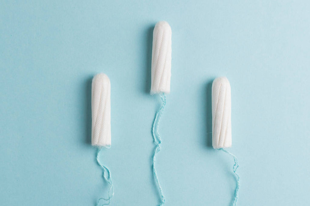 Tampone mestruale su sfondo blu. Ora delle mestruazioni. Igiene e protezione
 - Foto, immagini