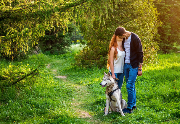 公園で犬を散歩若いカップル - 写真・画像