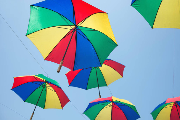 カラフルな傘の背景、空にカラフルなパラソル. - 写真・画像