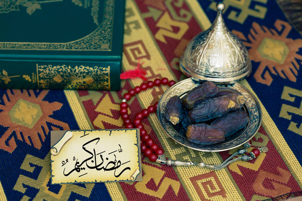 "Ramadan Kareem "tekstiä kortin päivämäärät ja Koraani matto
 - Valokuva, kuva