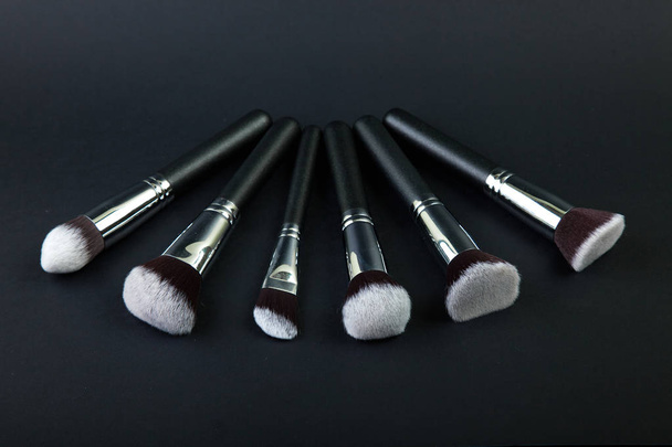 Professional makeup brushes on a black background, natural cloth - Zdjęcie, obraz