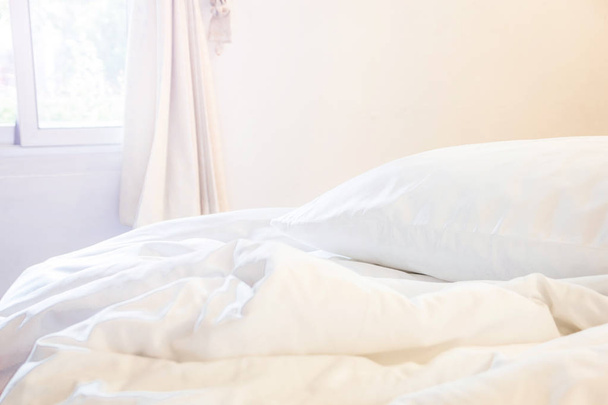 白い枕としわ厄介な長い夜冬で寝てから、左上側の照明が付いている寝室でベッドの上で毛布. - 写真・画像