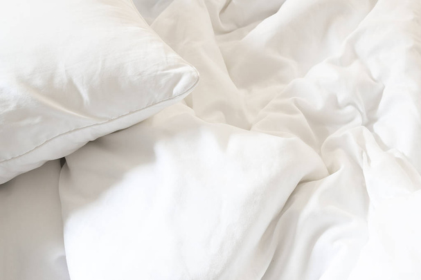 Beyaz yastık yatak ve uzun bir gece uyku dan yatak odasında, kırışıklık dağınık battaniye ile. - Fotoğraf, Görsel