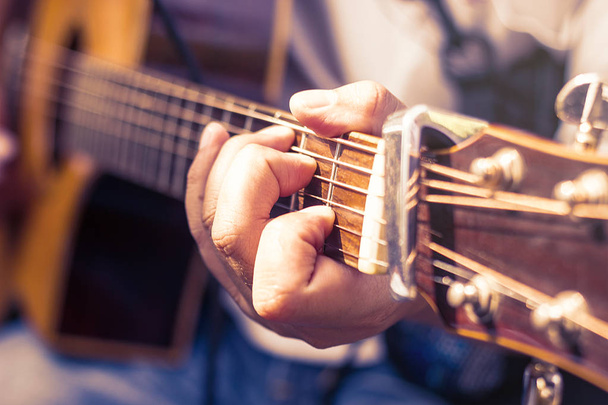 closeup of man's hands playing acoustic guitar, soft vintage style - Fotó, kép