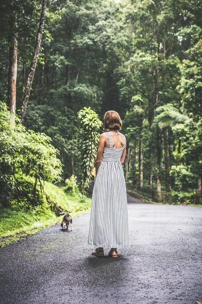 Young woman holding her puppy beagle dog in nature of tropical Bali island, Indonesia. - Photo, Image