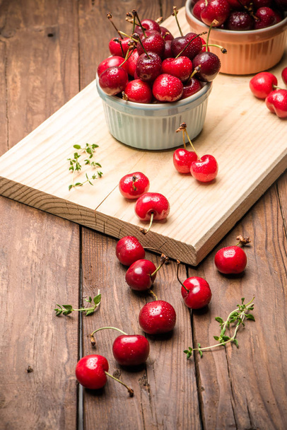 Red ripe cherries in ceramic bowls - Zdjęcie, obraz